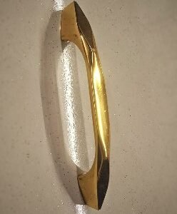 Sleek gold-finished pull handle with a sculpted, tapered design, offering a modern and luxurious touch to doors or furniture.