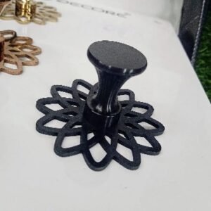 Decorative matt black powder coated cabinet knob with a flared top and intricate floral-patterned base plate, designed for luxury furniture.