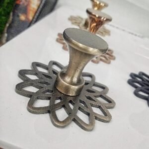 Decorative metal grey finished cabinet knob with a flared top and intricate floral-patterned base plate, designed for luxury furniture.