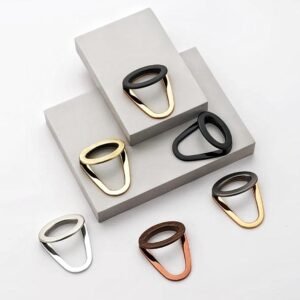 Set of six modern oval ring-style cabinet/wardrobe pull handles in gold, black, silver, copper, wood finish, and dual-tone designs, displayed on a white and grey background.