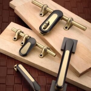 Premium gold and black finish door handle and tower bolt hardware set placed on wooden boards.