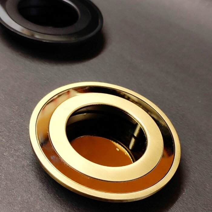 round recessed cabinet pull handles in black, silver, bronze, and gold finishes, placed on a dark background.